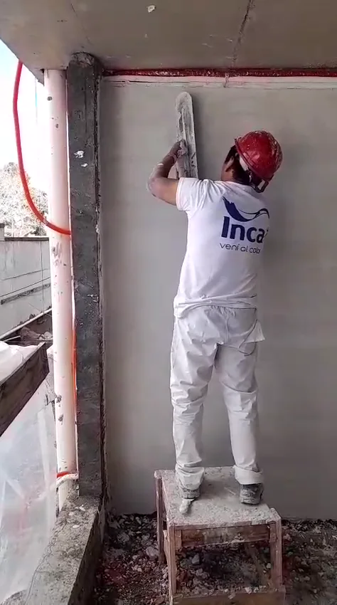 Operario enduyendo una pared hasta dejarla lisa